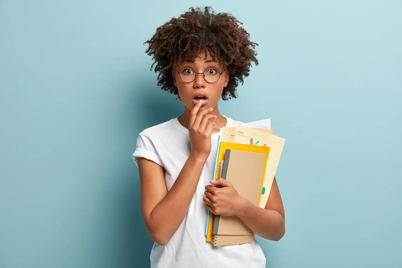 Prise de vue horizontale d’une jeune femme choquée, la main sur les lèvres, qui regarde d’un air surpris.